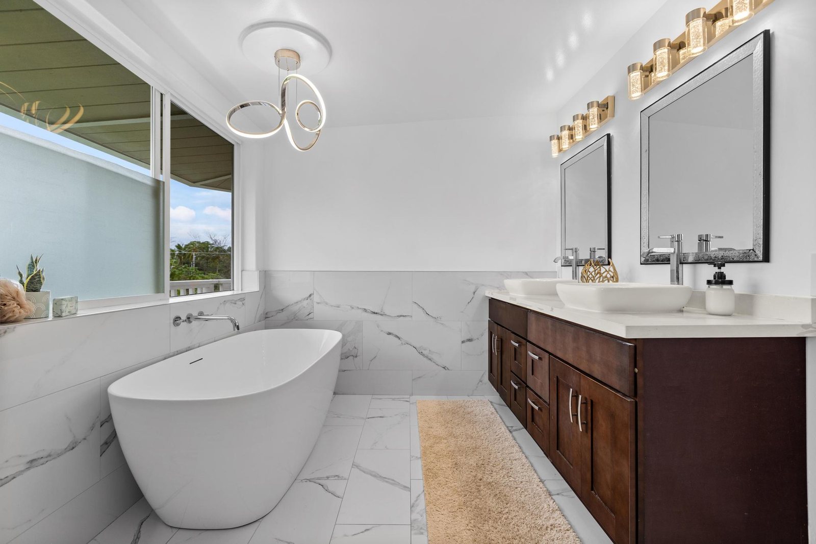 Primary bath with freestanding tub, double vanity and natural light