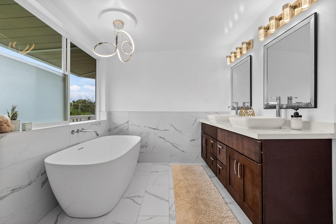 Primary bath with freestanding tub, double vanity and natural light