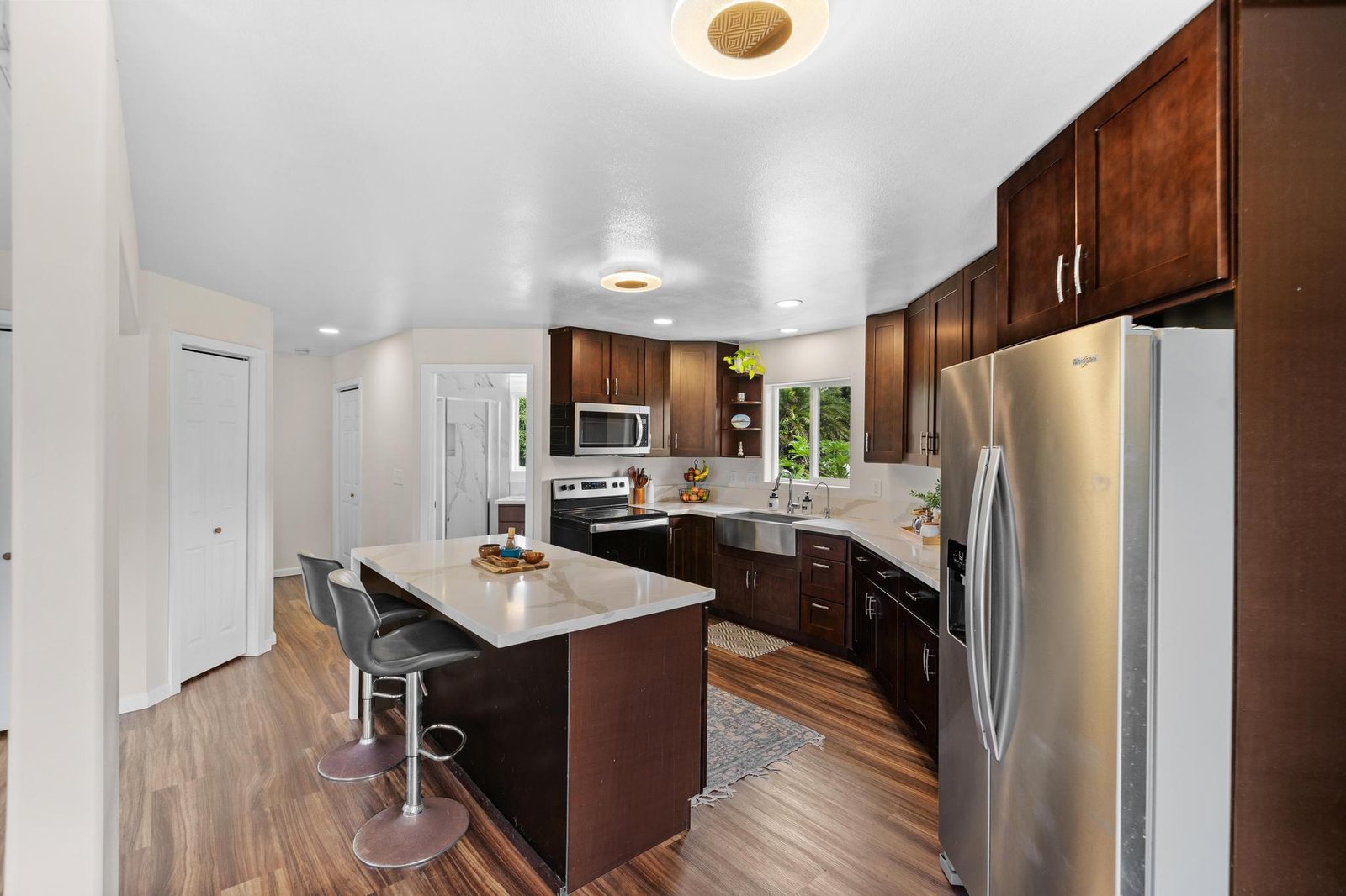 Kitchen island with bar seating and stainless refrigerator
