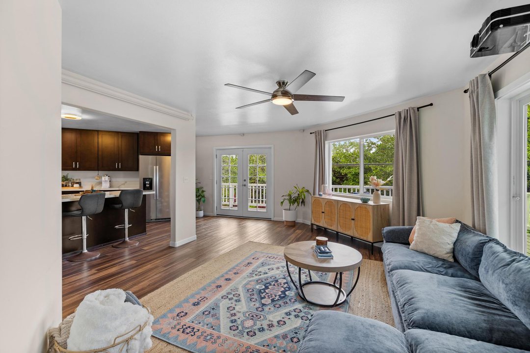 Family room opening to the kitchen, with French doors bringing in light from the lanai