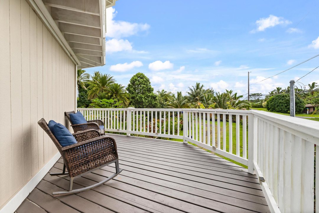 Rocking chairs on the upper wraparound lanai above the palms