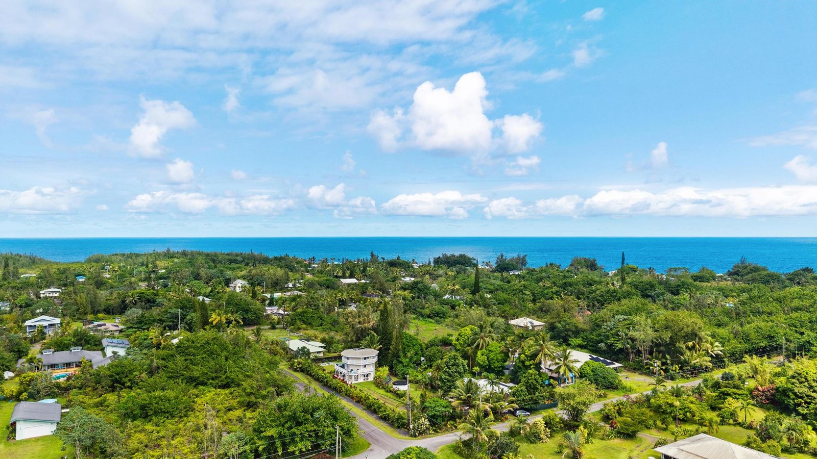 High aerial view over Kaloli Point toward the Pacific Ocean horizon