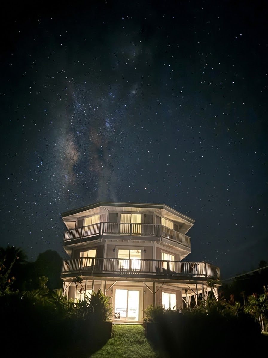 The Milky Way above the illuminated house at night